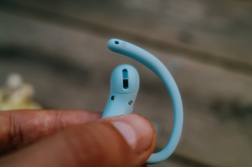 En OpenFit Air 2-propp holdt mellom to fingre, grillen mot kamera