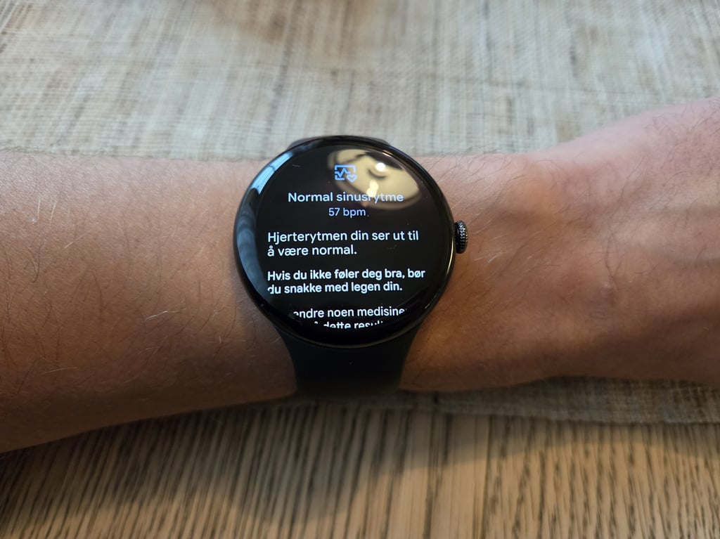 Pixel Watch 5 på håndleddet med resultatet av en EKG-måling på skjermen