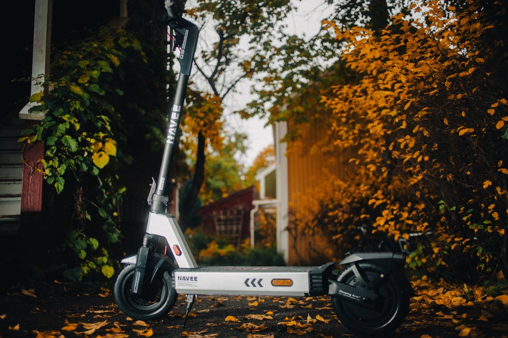 Navee G5 Pro elsparkesykkel parkert i en bakgård med gule høstblader