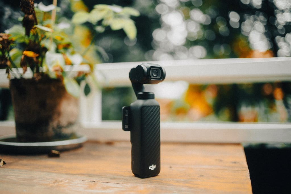 DJI Osmo Pocket 4 står på et trebord foran et hvitt rekkverk og potteplanter