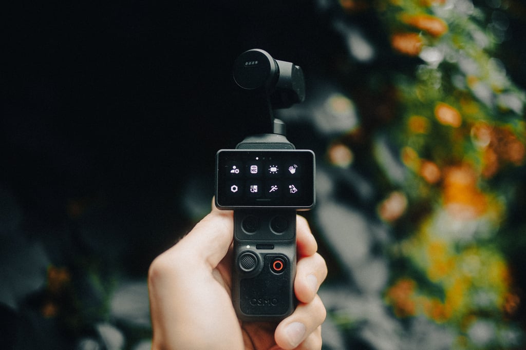 Hånd holder DJI Osmo Pocket 4 med menyikoner på den liggende skjermen
