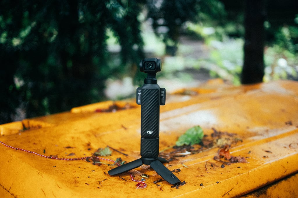DJI Osmo Pocket 4 på et lite stativ oppå et gult lokk utendørs