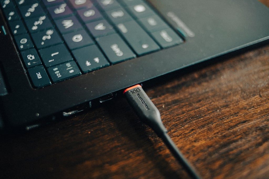 USB-C-kabelen fra Sandisk Portable SSD plugget inn i siden på en HP OmniBook X Flip 14