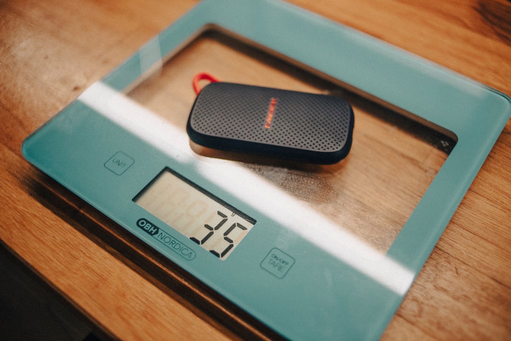 Sandisk Portable SSD på en kjøkkenvekt i glass som viser 35 gram