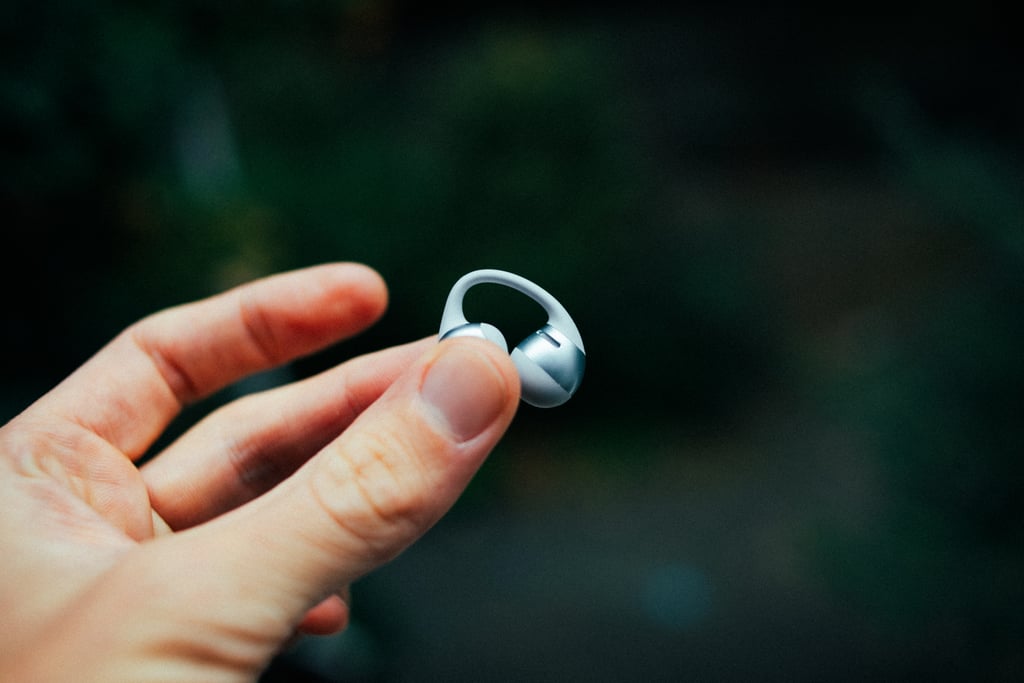 En enkelt Shokz OpenDots 2-propp holdt opp mellom tommel og pekefinger